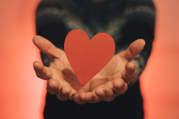 Red heart gravitating over both hands