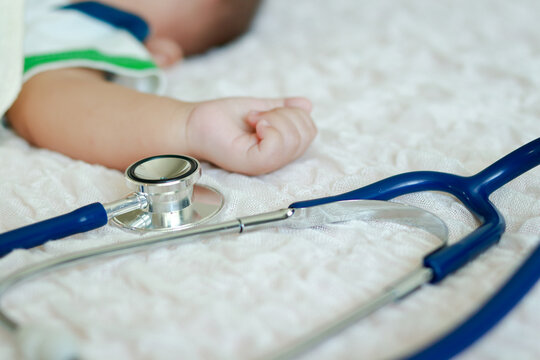 A Stethoscope Is Placed On A Bed Near A Male Infant. Baby Health Care Concept. Disease Of Young Children