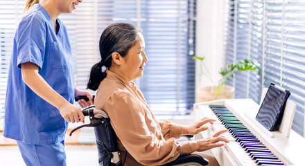 Portrait of asian nurse physiotherapist carer helping smiling and having fun teaching and play piano music lesson with asian senior elderly woman at home visit.senior retirement care concept