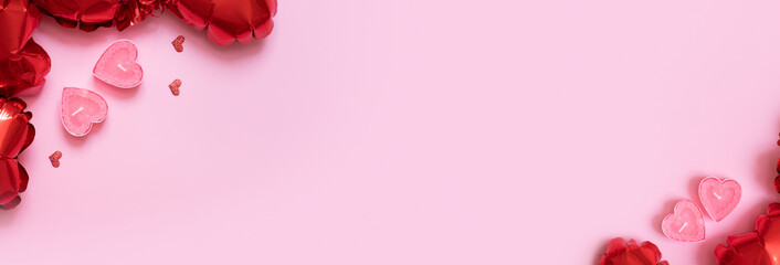 Gift box, candels and red heart shape baloons on pink background. Valentines Day background with...