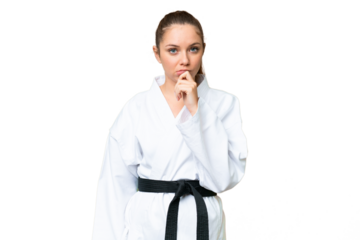 Young blonde woman doing karate over isolated chroma key background thinking