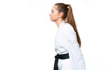 Young blonde woman over isolated chroma key background doing karate and saluting