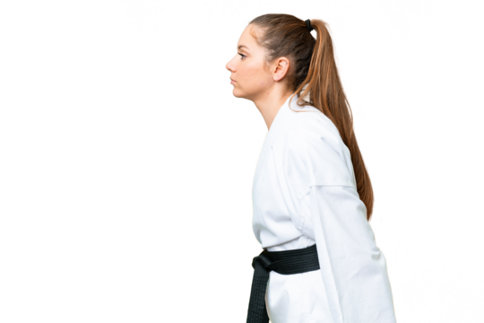 Young blonde woman over isolated chroma key background doing karate and saluting