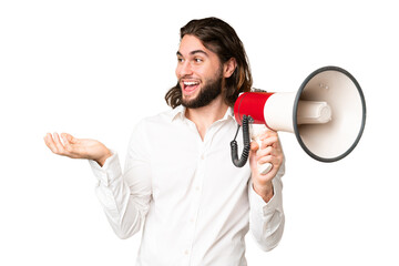 Young handsome man over isolated chroma key background holding a megaphone and with surprise facial...