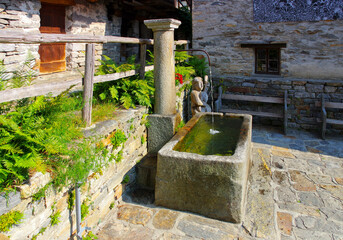 Brunnen in Sonogno im Verzascatal, Tessin in der Schweiz - typical well in Sonogno in the Verzasca Valley, Ticino in Switzerland - 557931489