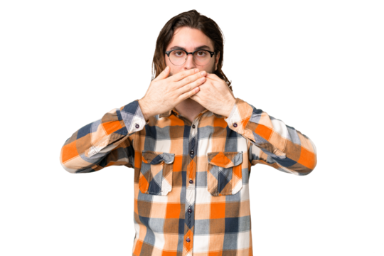 Young handsome man over isolated chroma key background covering mouth with hands