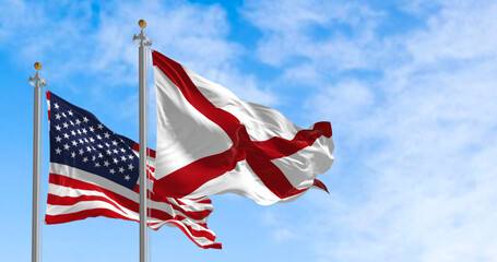 The flag of the state of Alabama waving alongside the national flag of the United States on a sunny day - Powered by Adobe