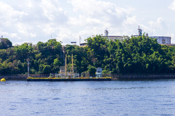 Fototapeta premium Industrial site on the river banks of Rio Amazonas in Brazil surrounded by the green rainforest