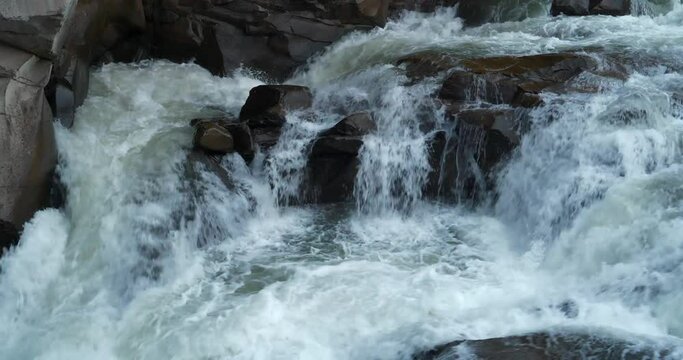 Powerful stream of water, waterfall in the mountains. Cinema 4K 60fps one minute relax video