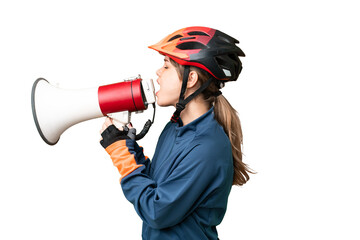 Young cyclist girl over isolated chroma key background shouting through a megaphone