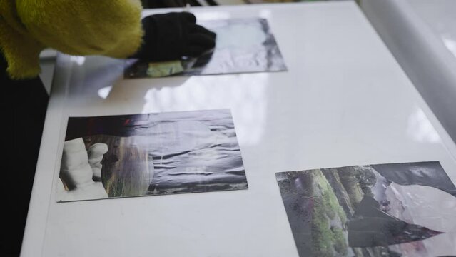 Gallery workers prepare paintings for the exhibition. Women, employees of the museum, arrange collages of paintings.