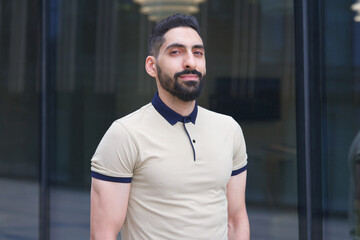 Portrait of Arab Arabian young handsome happy muslim bearded man with beard in casual clothes, islamic person, university or college student or successful businessman outdoors at campus, smiling
