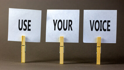 Use your voice symbol. Concept words Use your voice on white paper on a beautiful grey table grey background. Business and use your voice concept. Copy space.