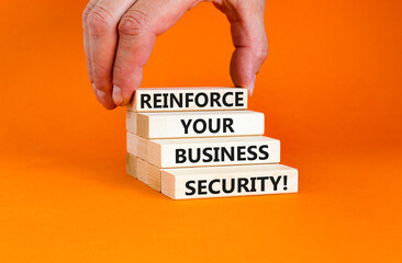 Reinforce your business security symbol. Concept word Reinforce your business security on blocks. Beautiful orange background. Business reinforce your business security concept. Copy space.