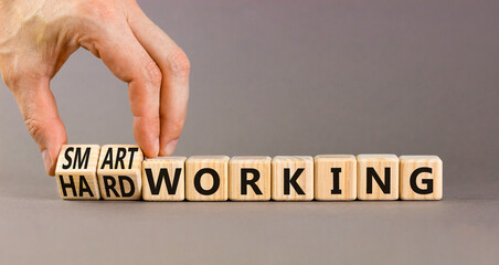 Smart or hard working symbol. Concept words Smart working and Hard working on wooden cubes. Businessman hand. Beautiful grey table grey background. Business smart hard working concept. Copy space.