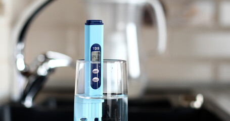 Measurement of TDS of water. Electronic pH meter in a glass of water.Filter for water purification....