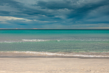Fototapeta na wymiar San Teodoro sand beach with turquoise sea water in Sadinia Italy, clouds in the sky during summer