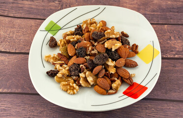 Nuts on a plate with almonds, walnut, brown raisin and blonde raisin