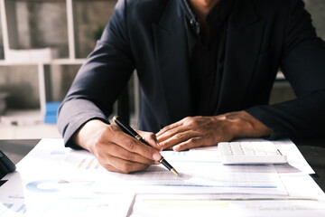 Businessman working on company financial statements, accountant reading financial statements while sitting in office.