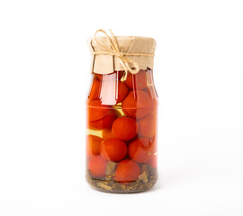 Pickled red cherry tomatoes in a glass jar isolated on white background. Food preservation for autumn or winter. Home storage. Canning, fermentation concept. Place for text. Copy space.