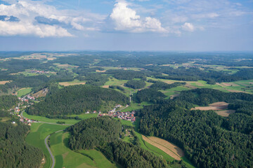 Fototapeta na wymiar View from a motor glider over the picturesque landscape of Franconian Switzerland/Germany with small villages
