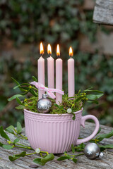 Weihnachtsdekoration mit Kerzen und Mistelzweigen in Tasse