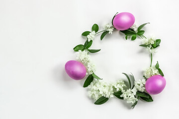 Easter layout made of colorful eggs and flowers on a light background . Circle wreath flat lay concept. copyspace