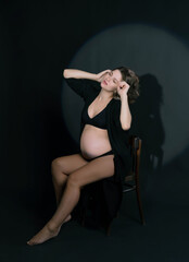 studio portrait of pregnant woman in dark key with gobo masks