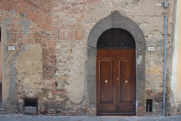 Fototapeta na wymiar Alte italienische braune Holztüre von einem Steinhaus.