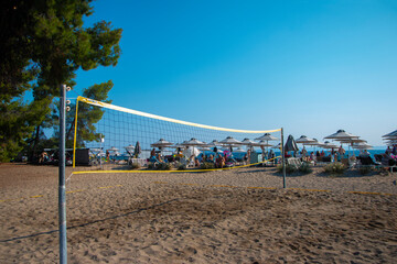 Fototapeta na wymiar Volleyball net on sand in summer background. Outdoor leisure games. Active lifestyle on beach with sand near sea or ocean with sky.