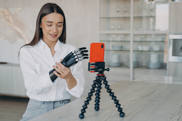 Amputee is taking video how to set a cyber arm. Attractive handicapped girl is blogger.