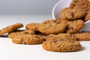cookies falling from bowl on the table, isolated on white background