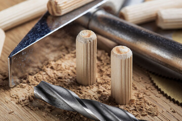 drill bit makes hole in wooden oak board for wooden dowel.