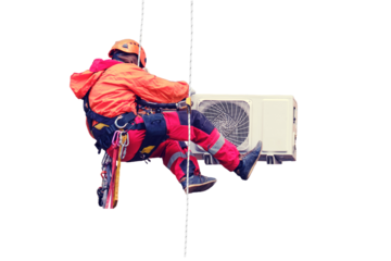 A male worker in a red uniform installs an air conditioner in a niche under the window, isolated on a white background