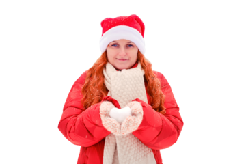 Woman holding snow in the shape of a heart in knitted mittens, isolated on a white background. Red-haired woman on Christmas and New Year Eve walks in the winter in red clothes