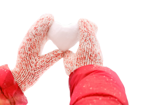 A woman in a santa hat holds a heart made of snow against a background of forest trees, close-up, isolated on a white background. Woman holding a heart shaped snowball for valentine day - Powered by Adobe