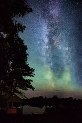 starry sky over a quiet lake in the forest. The Milky Way stretched across the sky, the stars illuminate the space in the night. shooting with a long shutter speed, the effect of the movement of stars