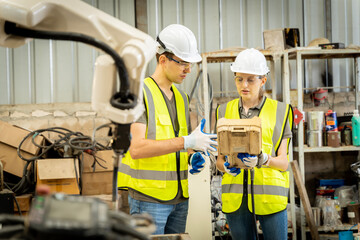 A team of male and female engineers meeting to inspect computer-controlled steel welding robots. Plan for rehearsals and installation for use.