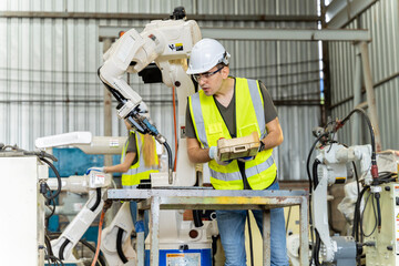 A team of male and female engineers meeting to inspect computer-controlled steel welding robots. Plan for rehearsals and installation for use.