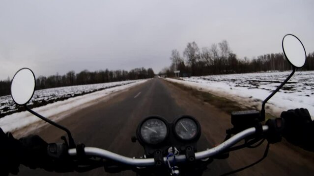 riding a motorcycle in winter in frost on the road in the snow.