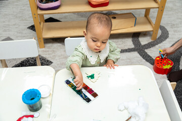 Toddler painting a blank object in montessori kindergarten