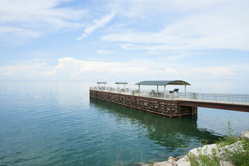 The pier at painsville township park. There is a beautiful blue sky over the smooth water.