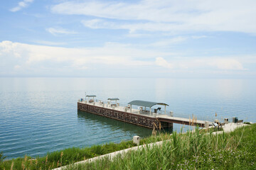 The pier at painsville township park. There is a beautiful blue sky over the smooth water.