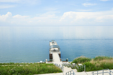The pier at painsville township park. There is a beautiful blue sky over the smooth water.