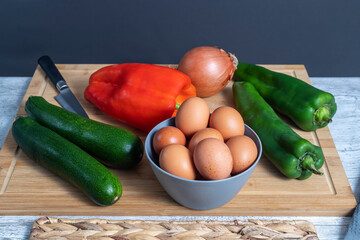 Pisto Manchego (Manchego ratatouille) with fried egg ingredients, red and green peppers, onion, zucchini and eggs. Concept typical and traditional food of Spain.