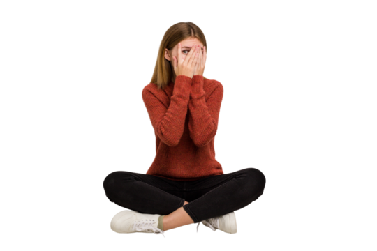 Young caucasian woman sitting on the floor cutout isolated