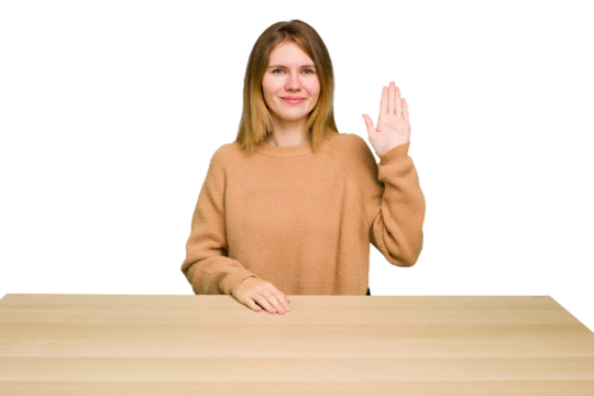 Young caucasian woman sitting on a chair in a desktop isolated smiling cheerful showing number five with fingers.
