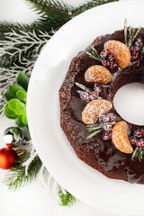 Chocolate cupcake on a white plate and New Year's decor on a white background.