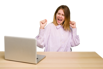 Young caucasian woman in a workplace working with a laptop isolated dancing and having fun.