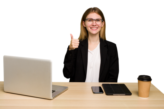 Young business caucasian woman working on her workplace cutout isolated smiling and raising thumb up